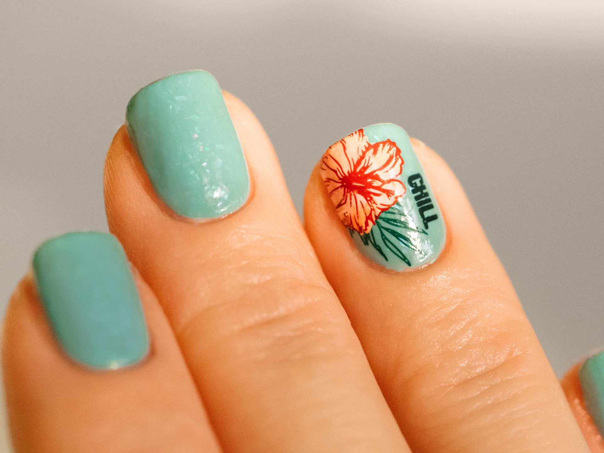 Nail design in blue green and tropical flower art